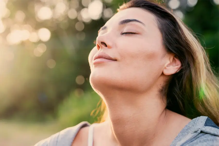 rostro de una mujer respirando en la naturaleza